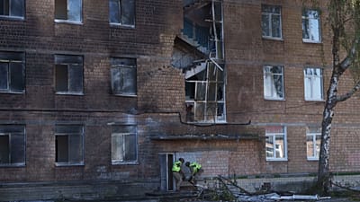 Des policiers transportent l'ogive non explosée d'un drone Shahed hors d'une école endommagée par une frappe russe sur Kyiv, 1 octobre 2026