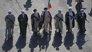 رجال دين شيعة يحملون بنادق يسيرون خلال عرض عسكري الطابع نظمته الدولة تحت شعار "جانفادا" (أو "التضحية من أجل إيران") في ساحة الثورة بطهران، إيران، يوم الجمعة 18 سبتمبر 2026. (ص