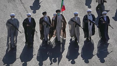 رجال دين شيعة يحملون بنادق يسيرون خلال عرض عسكري الطابع نظمته الدولة تحت شعار "جانفادا" (أو "التضحية من أجل إيران") في ساحة الثورة بطهران، إيران، يوم الجمعة 18 سبتمبر 2026. (ص