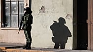 ARCHIVO: Un miembro de las fuerzas de seguridad mexicanas monta guardia cerca del ayuntamiento de Villa Unión, México, el martes 3 de diciembre de 2019.