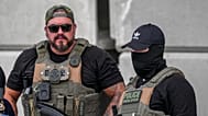 Immigration and Customs Enforcement officers stand at the scene where a man was shot in his vehicle by an ICE officer, Sunday, Sept. 20, 2026, in Austin, Texas