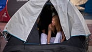 Woman wakes after camping overnight at Barcelona rent protest, Sept. 30, 2026.