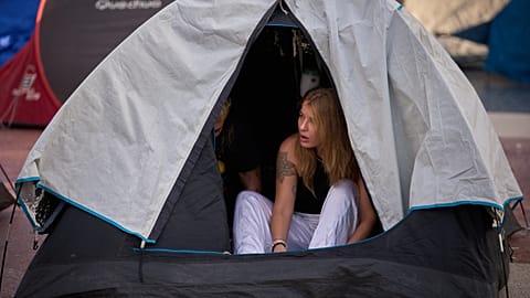 Une femme se réveille après avoir campé toute la nuit lors d'une manifestation contre les loyers à Barcelone, 30 septembre 2026.