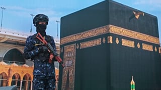 A Houthi soldier stands in front of a banner of the Kaaba at a protest against Riyadh's accusation that the group targeted Islam's holiest site, in Sana'a, 18 September 2026