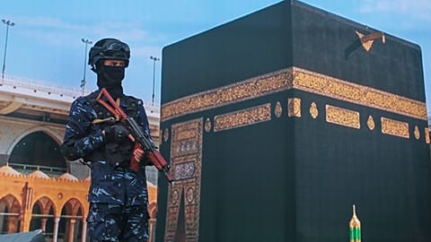 Боец хуситов стоит перед плакатом с изображением Каабы на акции протеста против обвинений Эр‑Рияда в попытке атаковать святыню ислама, Сана, 18 сентября 2026 года