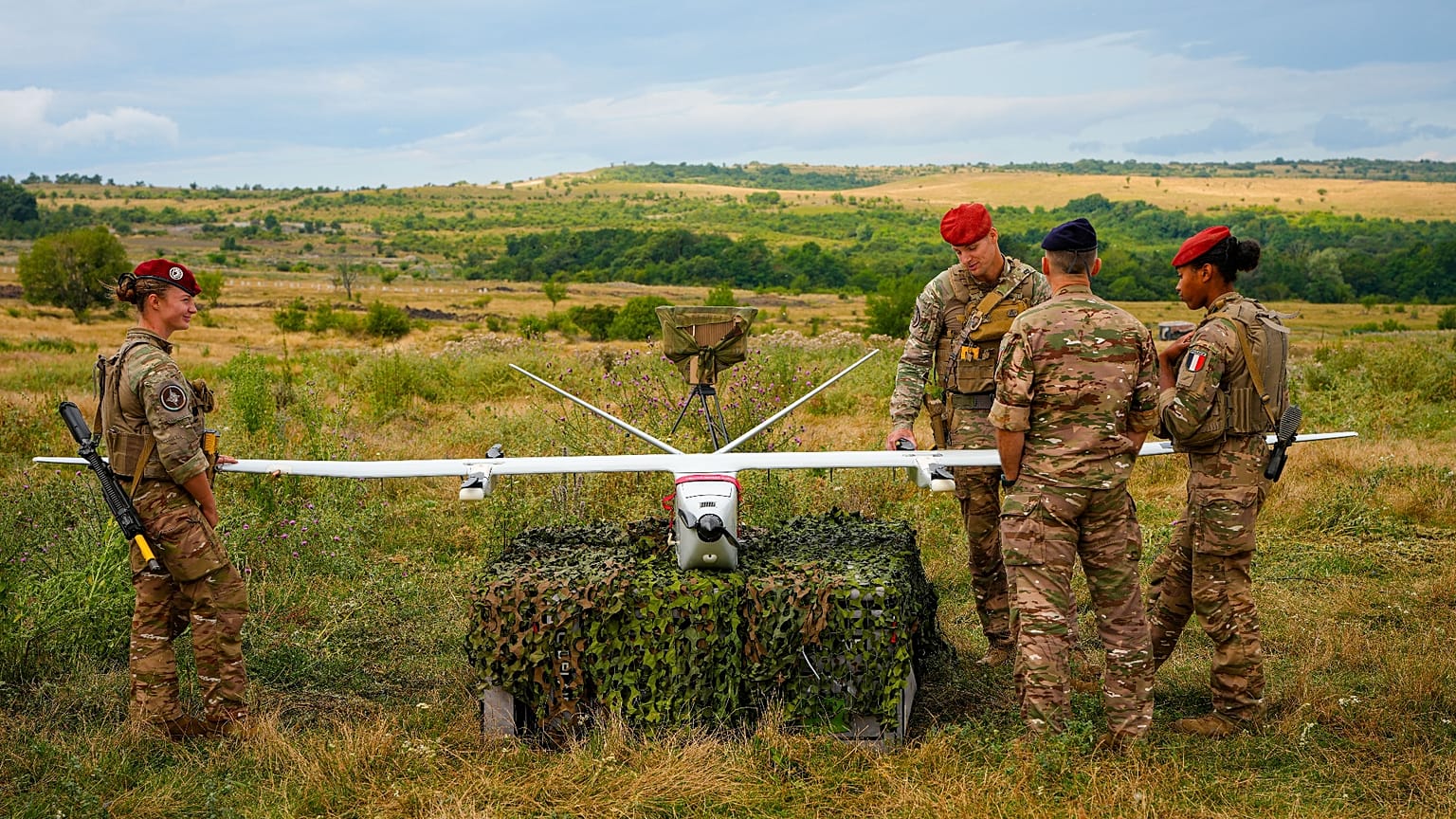 Servicemen and servicewomen look at a surveillance drone during the French-led NATO Eagle Spearhead exercise in Romania, Aug. 18, 2026.