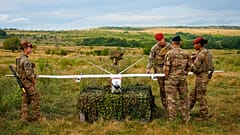 Servicemen and servicewomen look at a surveillance drone during the French-led NATO Eagle Spearhead exercise in Romania, Aug. 18, 2026.