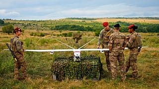 Servicemen and servicewomen look at a surveillance drone during the French-led NATO Eagle Spearhead exercise in Romania, Aug. 18, 2026.