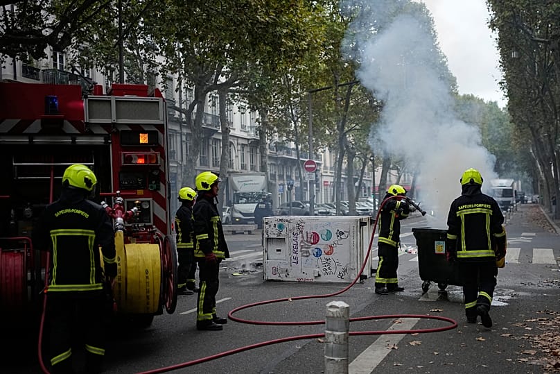 Firefighters extinguish a fire as students protest against under-resourced schools in Lyon, 2 October, 2026