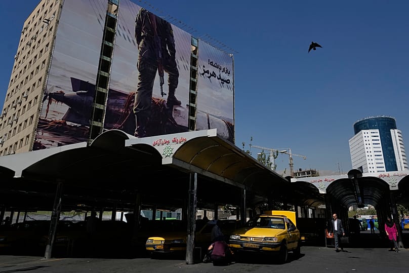 لوحة دعائية في طهران تُظهر عنصراً من الحرس الثوري يضع قدمه على مسيّرة أمريكية تحت الماء، 23 أيلول/سبتمبر 2026.