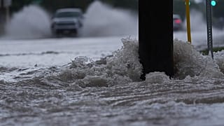 Archivo: Un vehículo circula por una carretera inundada mientras fuertes lluvias azotan la zona