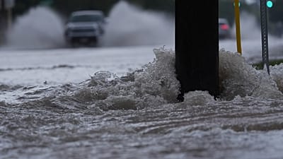 Archivo: Un vehículo circula por una carretera inundada mientras fuertes lluvias azotan la zona