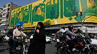 امرأة عند تقاطع طرق أمام لوحة إعلانية تعرض صوراً إحياءً للذكرى السنوية الثانية لمقتل حسن نصر الله، في طهران، إيران، يوم الأحد 27 سبتمبر 2026.