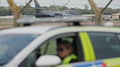 تستعد قاذفة من طراز "بي-1" (B-1) للإقلاع، بينما يتمركز ضباط شرطة عند نقطة تفتيش بالقرب من قاعدة "فيرفورد" الجوية التابعة لسلاح الجو في فيرفورد بإنجلترا، في 29 سبتمبر 2026
