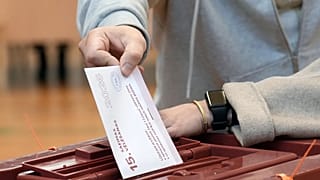 A voter casts his ballot at the parliamentary election at a polling station in Riga, Latvia, Saturday, Oct. 3, 2026. 