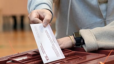 Wyborca oddaje głos w lokalu wyborczym w Rydze na Łotwie podczas wyborów parlamentarnych, sobota, 3 października 2026 r.