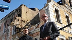 Ukraine's President Volodymyr Zelenskyy, centre, and German Chancellor Friedrich Merz speak to media with National Academy of science building damaged after a Russian drone st