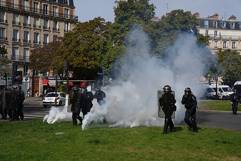 Des policiers progressent dans les gaz lacrymogènes face aux élèves lors d'une manifestation contre le manque de moyens, vendredi 2 octobre 2026 à Paris.