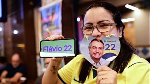 A supporter of opposition presidential candidate Sen. Flavio Bolsonaro poses for a picture as she waits for election results in Rio de Janeiro, Sunday, Oct. 4, 2026