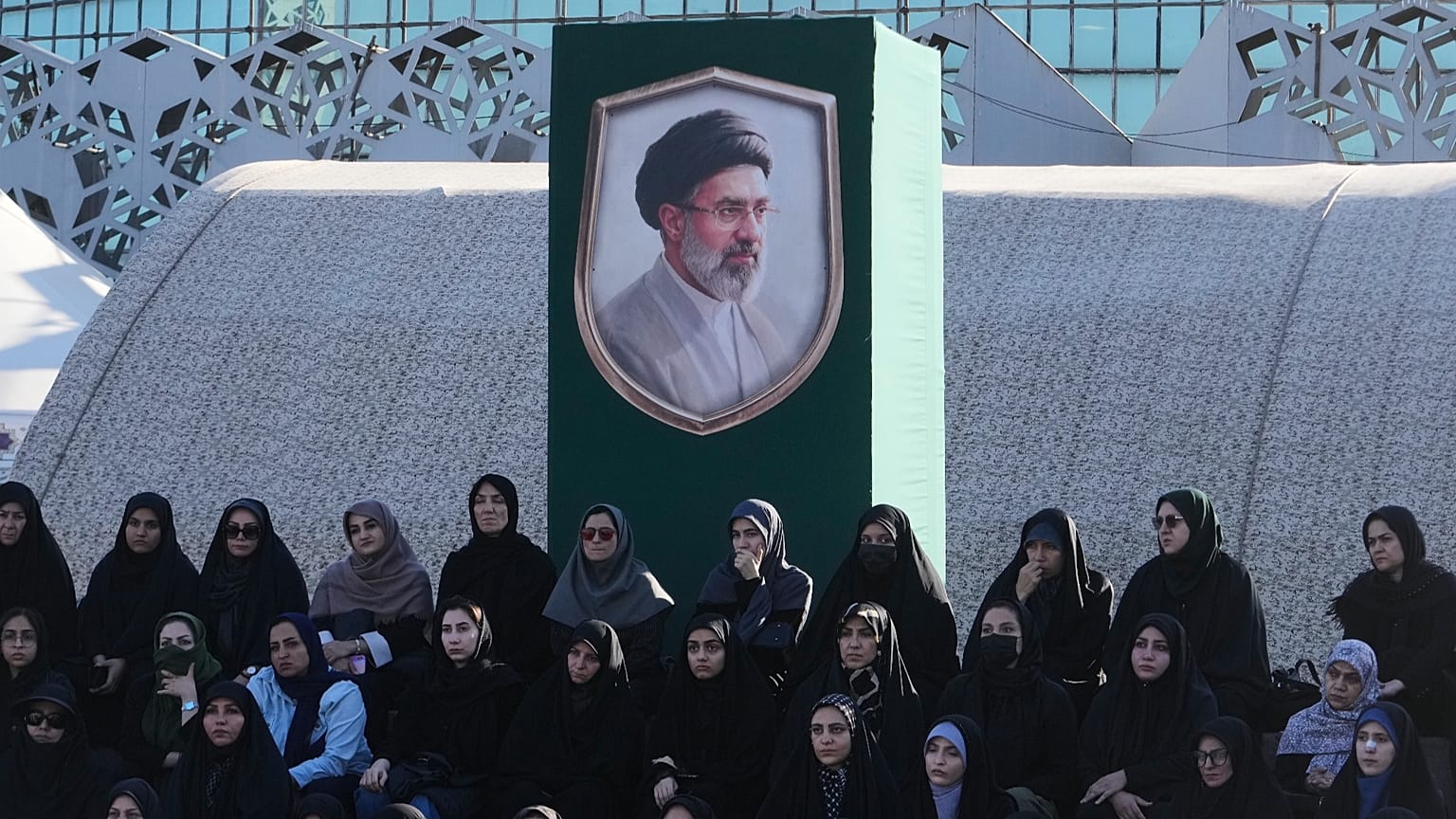 يجلس متطوعون أسفل صورة للمرشد الأعلى الإيراني آية الله مجتبى خامنئي أثناء حضورهم دورة تدريبية عسكرية في معسكر أقيم في ساحة الإمام الحسين بطهران، يوم الأحد، 4 أكتوبر 2026. 