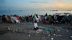 A migrant prays during the morning on El Trampolín Beach in the Spanish enclave of Ceuta Thursday, Oct. 1, 2026.