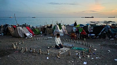 A migrant prays during the morning on El Trampolín Beach in the Spanish enclave of Ceuta Thursday, Oct. 1, 2026.