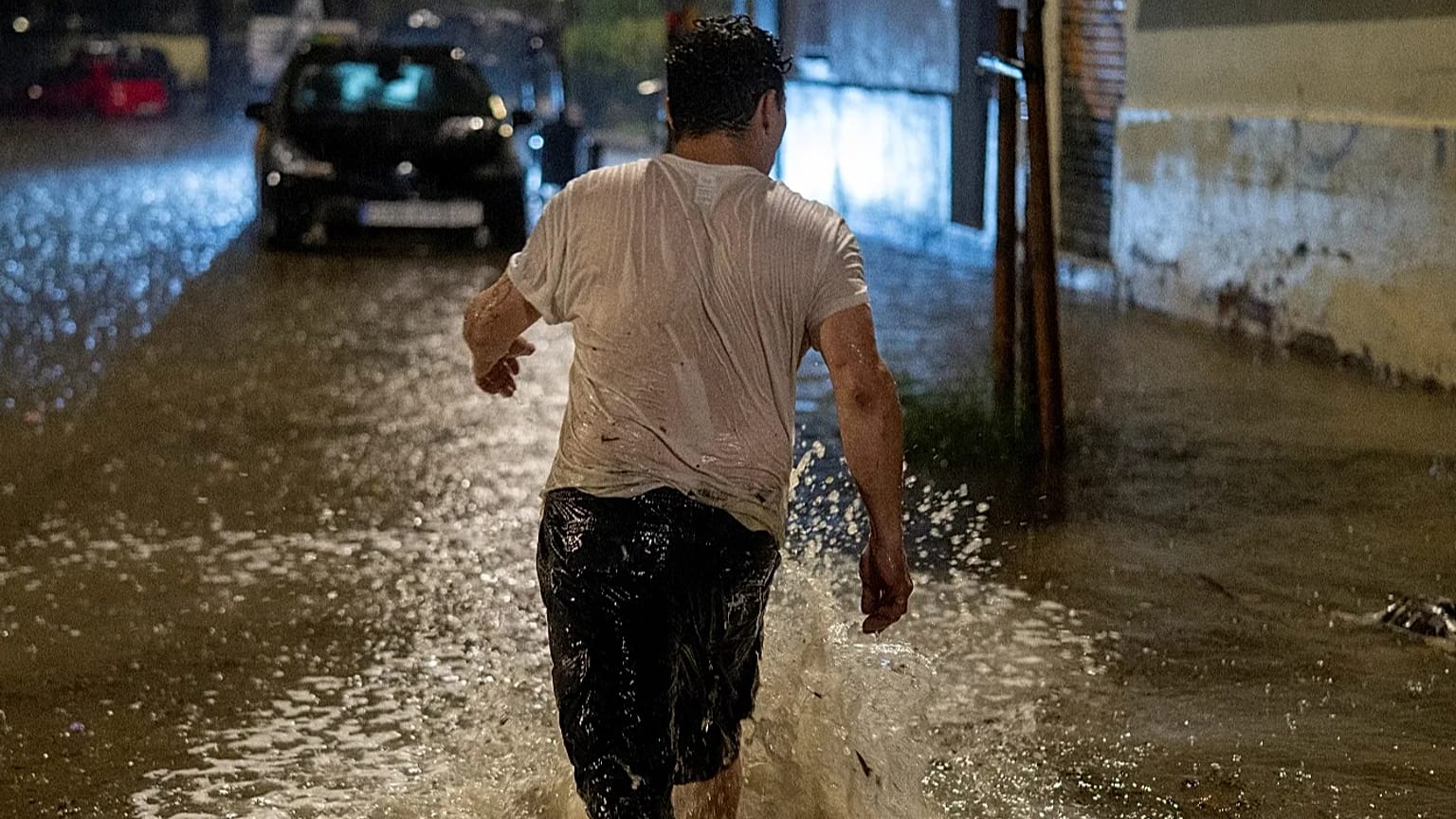 Un hombre camina por una calle inundada bajo fuertes lluvias en L'Hospitalet de Llobregat, en las afueras de Barcelona, España, el domingo 4 de octubre de 2026.