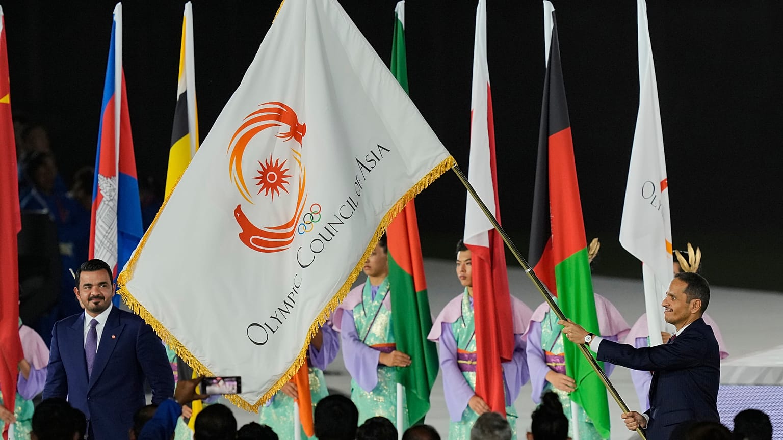 OCA President Sheikh Joaan bin Hamad Al Thani looks on as Qatar's Prime Minister Sheikh Mohammed bin Abdulrahman Al Thani holds the OCA flag in Nagoya, Japan on 4 Oct,, 2026.