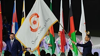 Prezydent OCA szejk Dżoan ibn Hamad Al Sani przygląda się, gdy premier Kataru szejk Mohammed ibn Abdulrahman Al Sani trzyma flagę OCA w Nagoi, 4 października 2026 r.