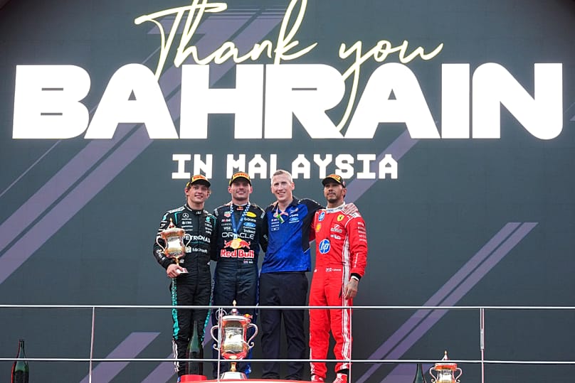 Red Bull driver Max Verstappen celebrates his Bahrain Grand Prix win with Kimi Antonelli, left, and Lewis Hamilton on the podium in Sepang, Malaysia, 4 Oct., 2026.