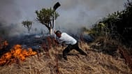 Un vecino combate un incendio forestal con una pala durante un fuego en Tábara, en el noroeste de España, el 19 de julio de 2022.