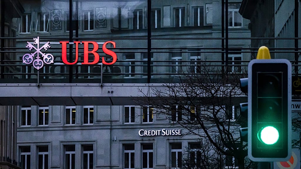 FILE. A traffic light signals green in front of the logos of the Swiss banks Credit Suisse and UBS in Zurich, Switzerland, 19 March 2023