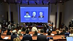 Portraits of Karl Deisseroth, Peter Hegemann and Georg Nagel are shown on the screen as they are awarded the 2026 Nobel Prize in Physiology or Medicine.