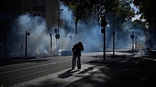A student runs out the teargas during a protest against under-resourced schools in Lyon, France, Friday, Oct. 2, 2026