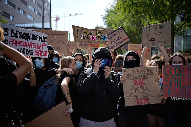 A student holds a board reading "We want to be supported, not overburdened" during protest against under-resourced schools, in Lyon, France, Friday, Oct. 2, 2026