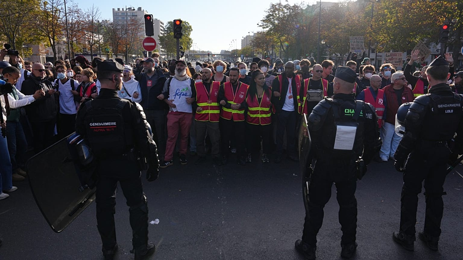 Riot police face union members and high school students as they gather before a demonstration against under-resourced schools in Paris, Tuesday, Oct. 6, 2026