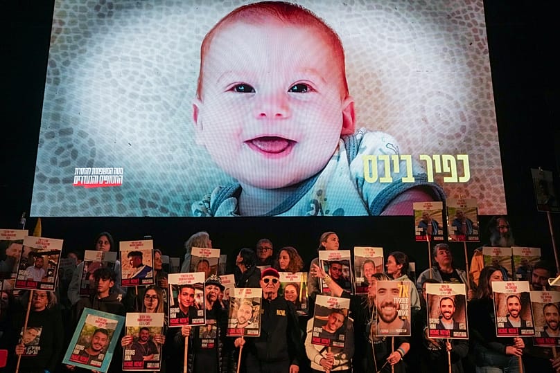 Demonstrators in Tel Aviv hold portraits of hostages held by Hamas as a video featuring Kfir Bibas, who, with his mother Shiri and his brother Ariel was murdered by Hamas