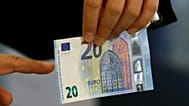 Arquivo - Yannis Stournaras, governador do Banco da Grécia, mostra a nova nota de 20 euros em Atenas, terça-feira, 24 de novembro de 2015.