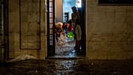 Unos residentes achican agua de sus viviendas durante unas fuertes lluvias en L'Hospitalet de Llobregat, en las afueras de Barcelona, el 4 de octubre de 2026.