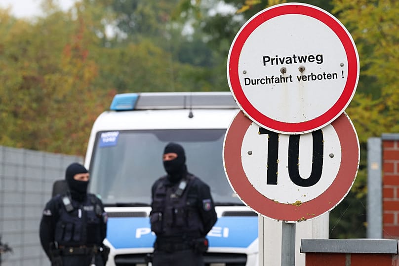 Police officers stand at the entrance of former intelligence chief August Hanning's home, who was arrested on suspicion of espionage, in Nordwalde, Tuesday, Oct. 6, 2026