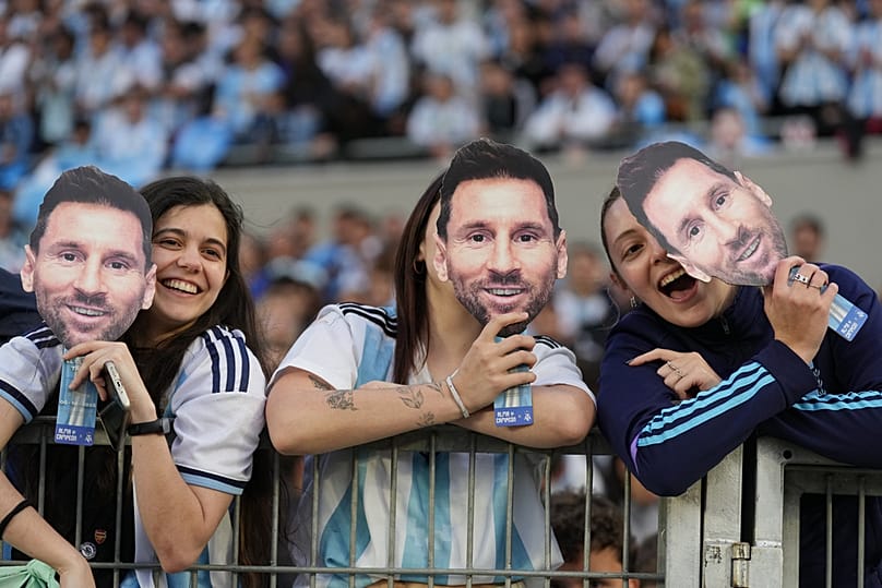 Fans hold masks depicting Lionel Messi before his final match for Argentina, a soccer friendly against Benin, in Buenos Aires, Argentina, Tuesday, Oct.6, 2026