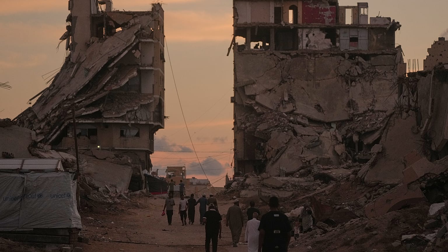 فلسطينيون يسيرون في شارع تحيط به مبانٍ دمرتها غارات إسرائيلية في غزة، الثلاثاء 6 أكتوبر/تشرين الأول 2026. 