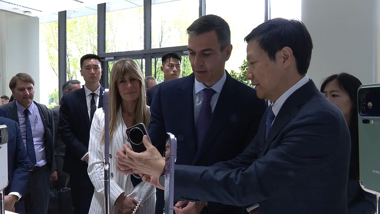 Begoña Gómez, a la izquierda, asiste a una demostración del presidente de Xiaomi en Pekín, China, junto al presidente Sánchez
