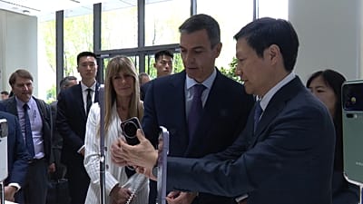 Begoña Gómez, a la izquierda, asiste a una demostración del presidente de Xiaomi en Pekín, China, junto al presidente Sánchez