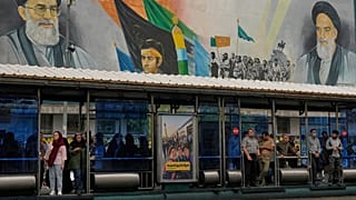 يقف ركاب عند محطة للحافلات في شارع "الثورة الإسلامية" وذلك في طهران، إيران، يوم الثلاثاء 6 أكتوبر 2026.