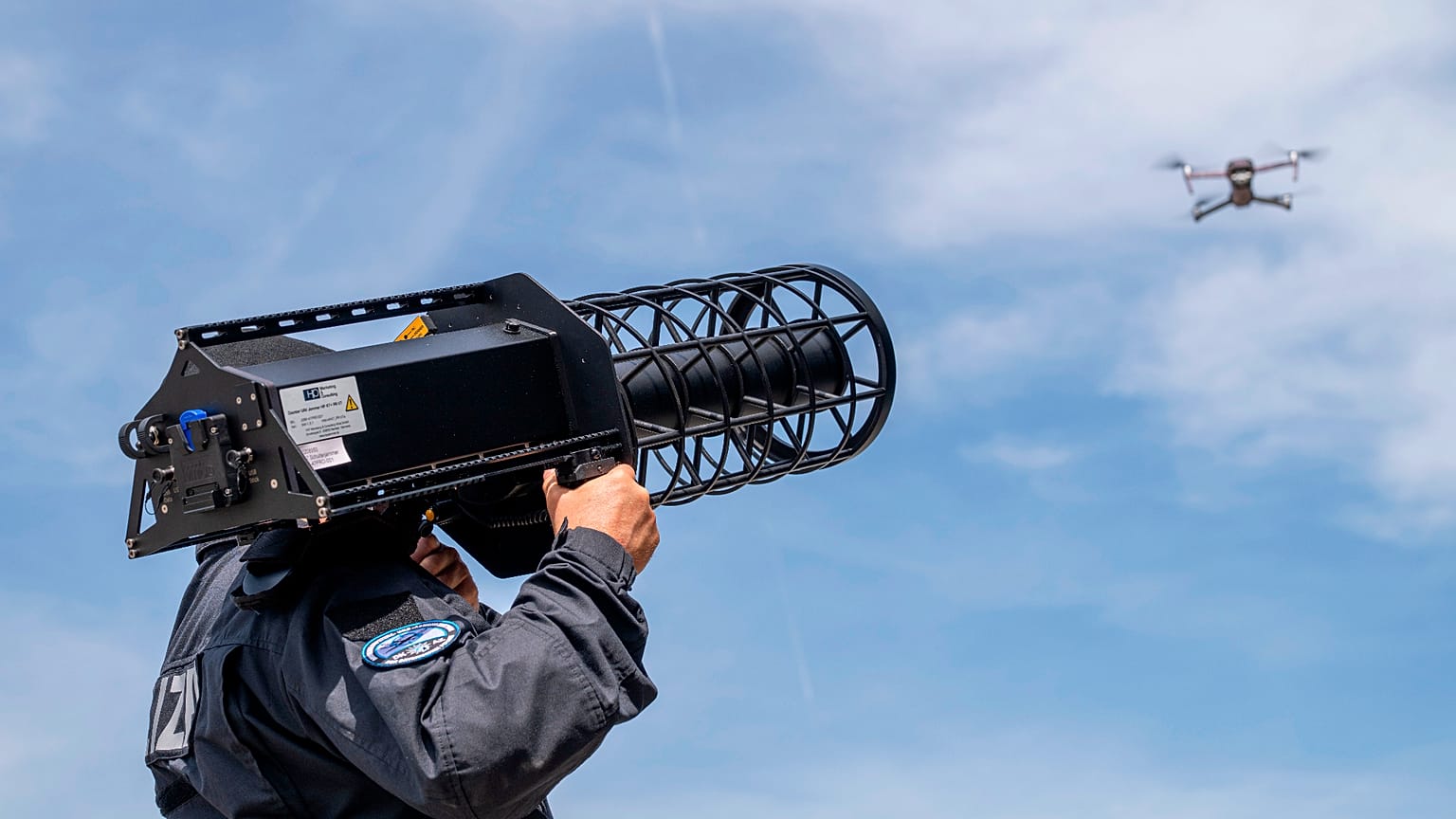 A police officer stands behind a drone with a "Counter LAV Jammer HP 47 + PR V7" during a demonstration as part of the opening of the drone defense center in in Erding, Germay