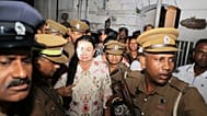 Prison officers escort Shiranthi Rajapaksa, wife of Sri Lanka's former President Mahinda Rajapaksa, to a prison vehicle outside a court in Colombo, Wednesday, Oct. 7, 2026