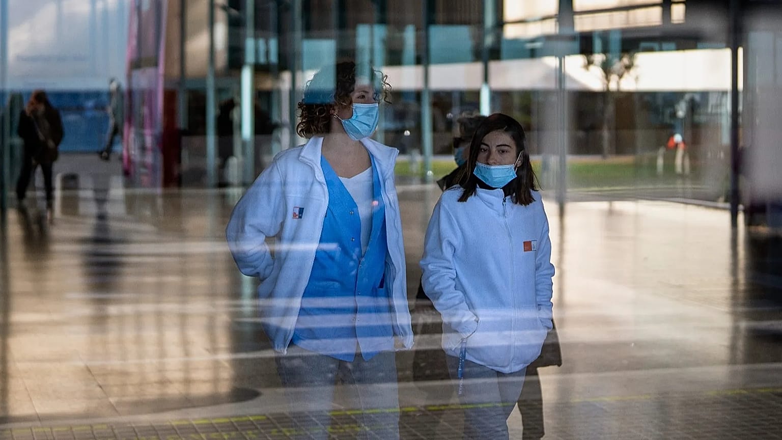 ARCHIVO: Personas que llevan mascarillas como medida de precaución caminan por el interior de un hospital en Barcelona, ​​España, el lunes 8 de enero de 2024.