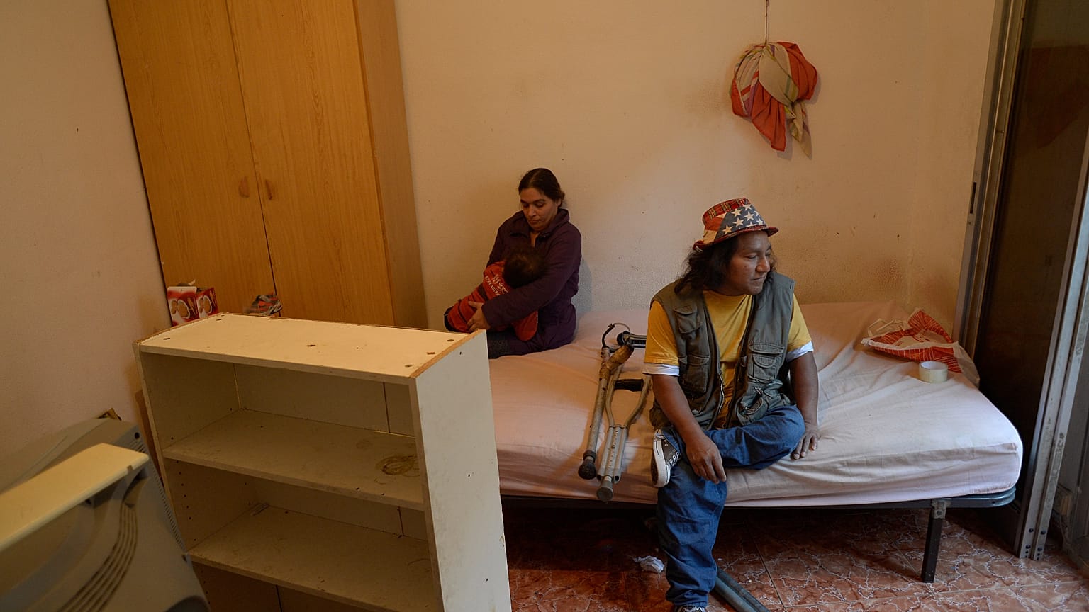 Miguel Mite, de 51 años y afectado por poliomielitis, junto a su pareja Carolina Bravo (38), en el dormitorio del piso de alquiler del que fueron desahuciados