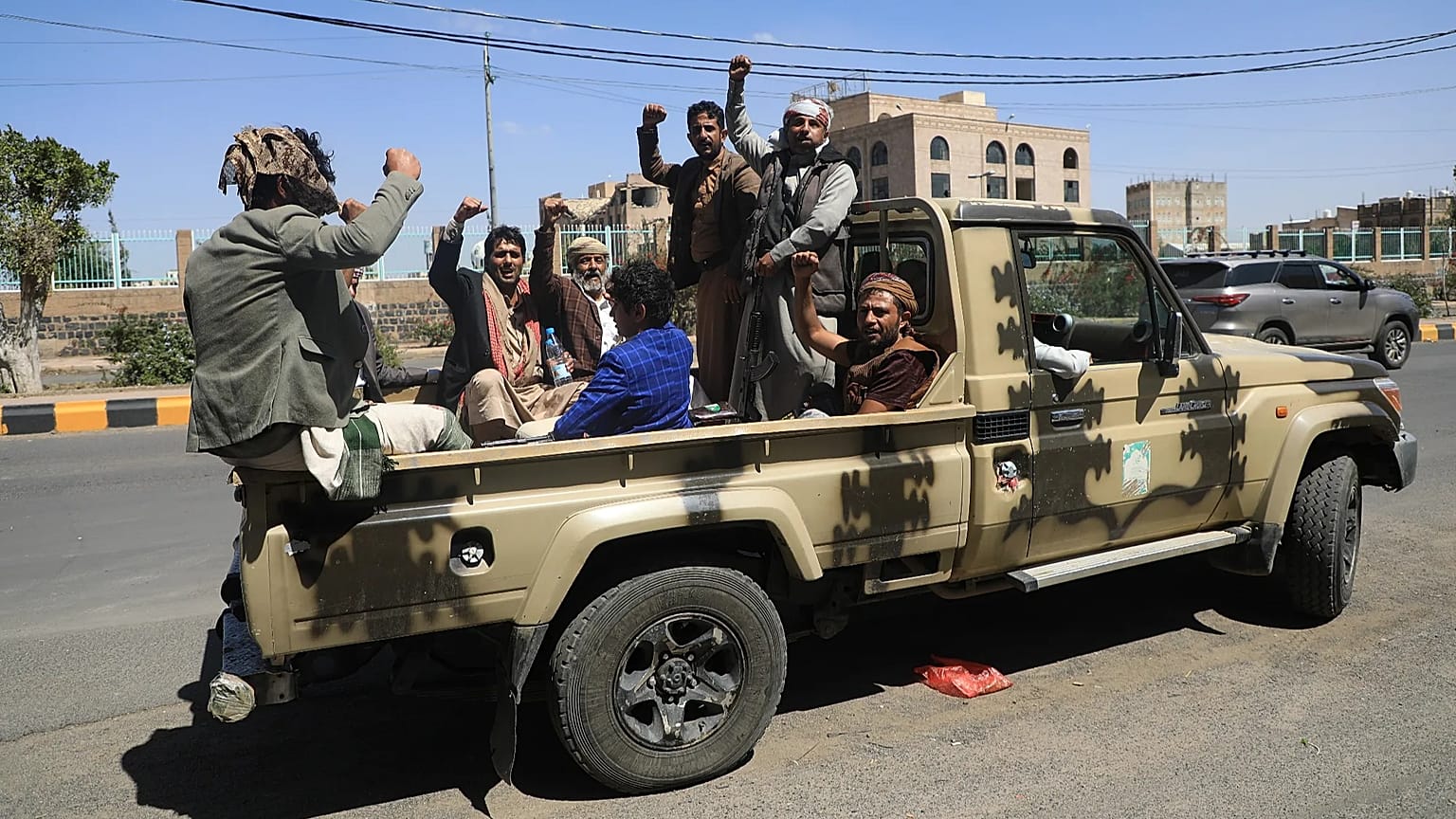 FILE: Houthi supporters chant slogans while riding in the back of a pickup truck at an armed tribal rally in Sanaa, 7 October 2026